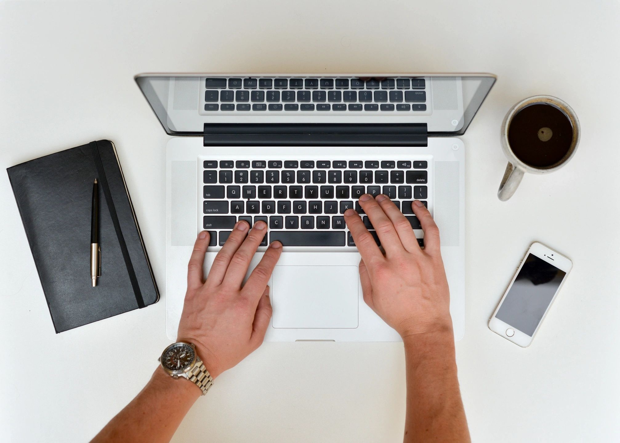 Hands typing on a laptop